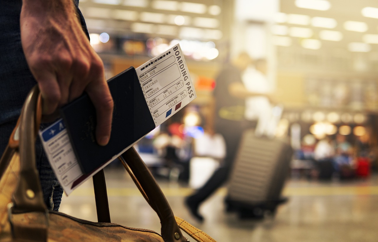 Someone Who Hold A Passport With A Boarding Pass In Airport